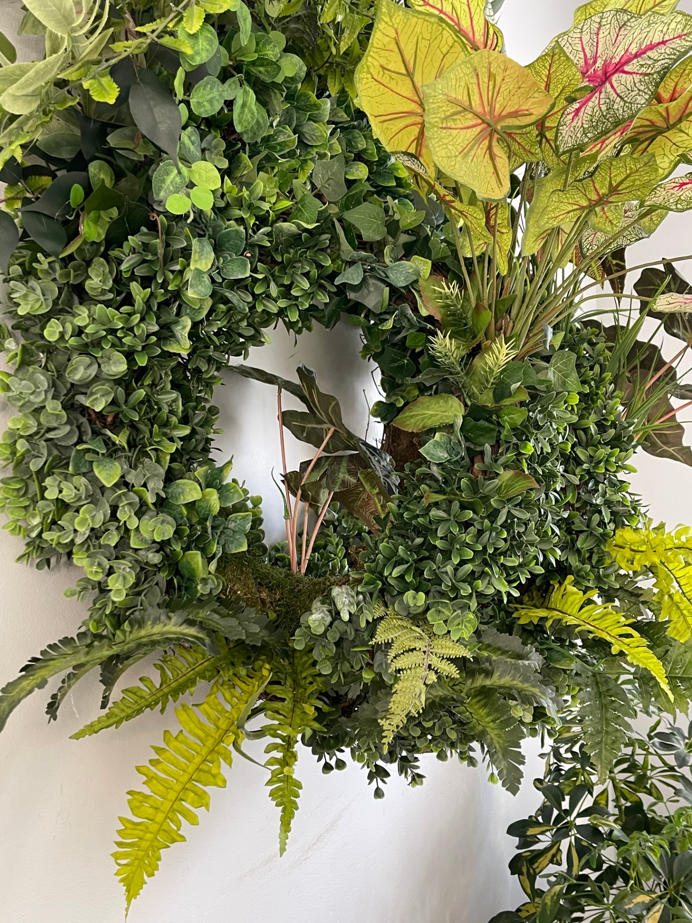 Grand Collection — biophilic wreath at scale, side angle showing dimensional depth.